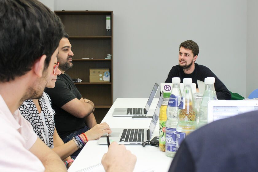 Digitale Leute - Daan Löning - Helpling - Bei der Teambesprechung haben viele einen Laptop oder einen Block dabei.